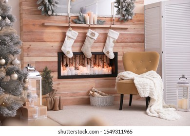 Fireplace with Christmas stockings in room. Festive interior - Powered by Shutterstock