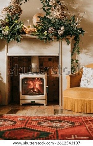 A fireplace with a fire burning in it and a chair in front of it. The room has a warm and cozy atmosphere