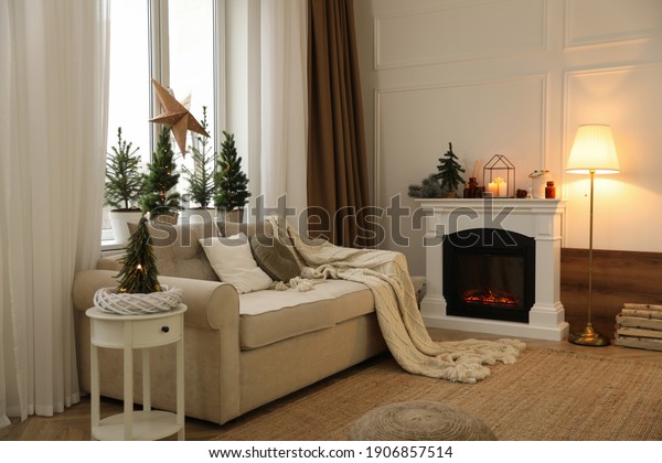 Fireplace in room with Christmas decorations.\
Interior design