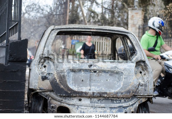 Fires in Greece Burnt car on road. Burnt tire and\
molten metal