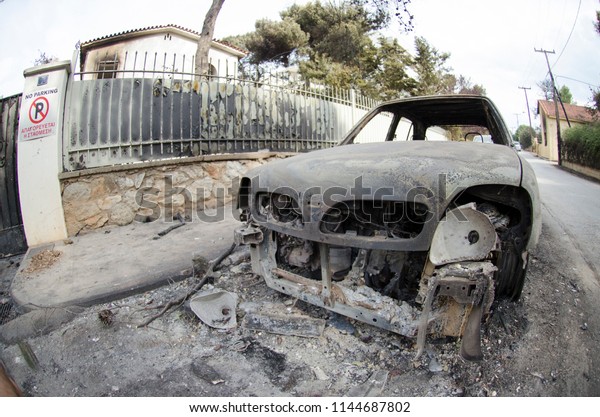 Fires in Greece Burnt car on road. Burnt tire and\
molten metal