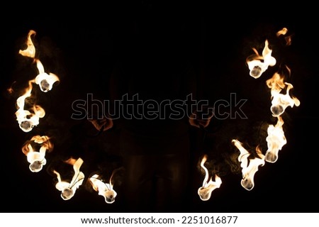Fireshow in dark. Two steel fans with hot flames. Burning kerosene.