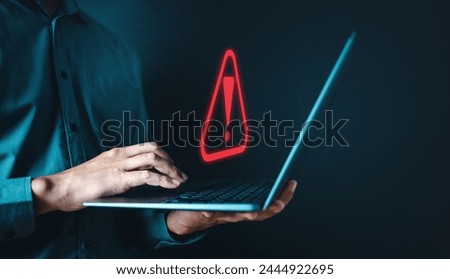 firewall, network, server, spyware, theft, information, stealing, danger, system, phishing. A man is holding a laptop with a red exclamation point on the screen. Concept of urgency or danger.