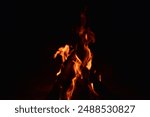 firewood burns, fire coals at night. Red hot coals glowing on a dying campfire pit. Orange glow from the coals at the stake at night. flames on a black background