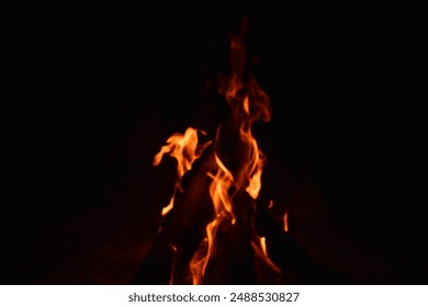 firewood burns, fire coals at night. Red hot coals glowing on a dying campfire pit. Orange glow from the coals at the stake at night. flames on a black background - Powered by Shutterstock