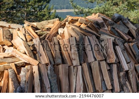 Firewood logs stacked in piles outside cottage