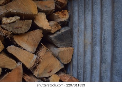 Firewood Stacked In Old Tin Wood Shed. Close Up.