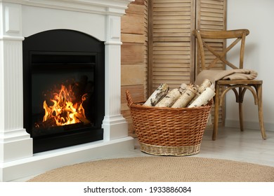 Firewood In Wicker Basket Near Fireplace Indoors