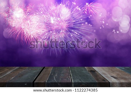 Firework display in multi colour and soft light bokeh over wooden floor.Time for celebration.