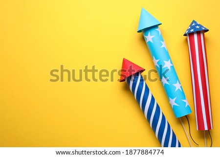 Firework rockets on yellow background, flat lay with space for text. Festive decor