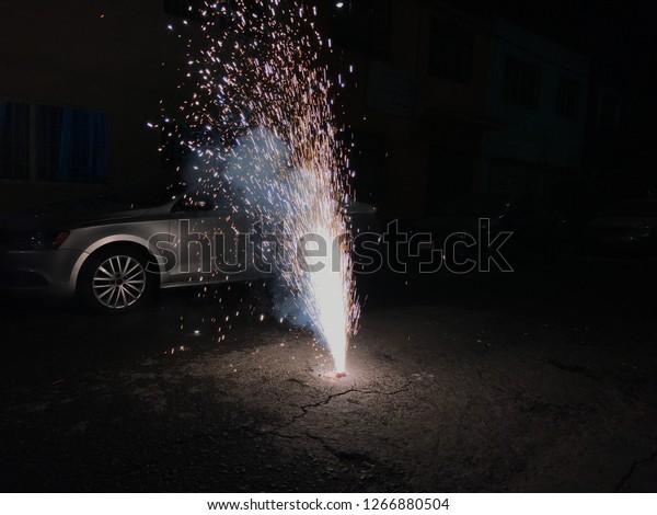 Firework show. pyrotechnic fires in street and\
in the background\
vehicles