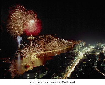 Fireworks Blooming In The Night Sky Tinging The Ocean Red
