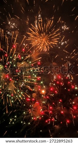 Fireworks exploding in the night sky, creating a festive celebration atmosphere with bright sparks and glowing trails against a dark background.