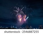 Fireworks in the night sky with tall buildings back ground