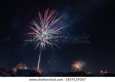 Fireworks over the roofs of houses