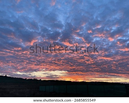 Firey sunset clouds in evening sky 