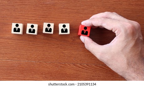 Firing, Bad Employee And Demotion Concept. Hand Pick Red Wooden Cube With Employee Icon