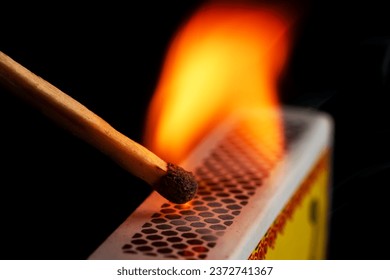 Firing point safety match. Close-up view to strike matches for matchbox. Detail of ignition matches for matchbox. Macro lighting of a match striking out a matchbox. Closeup safety match flame.