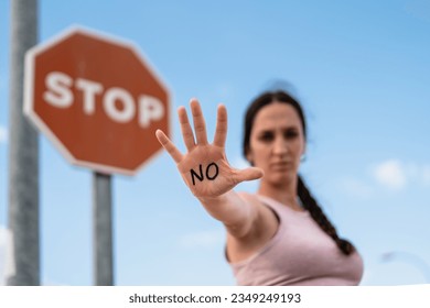 firm woman expressing the action of enough with her hand, no or stop, no violence, no permission