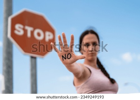 firm woman expressing the action of enough with her hand, no or stop, no violence, no permission