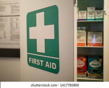 First aid cabinet on an office wall with various pills and medications on the inside