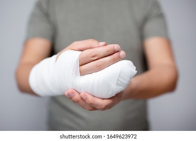 Konzept der ersten Hilfe - Nahaufnahme von zerbrochener männlicher Hand mit Verband und Gips