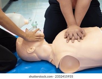 First aid CPR chest pumping. Instructor showing resuscitation technique with holding oxygen mask. Basic life support training. - Powered by Shutterstock