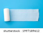 First aid, injury protecting wrapping and wound dressing concept clean cotton gauze bandage isolated on blue background with copy space