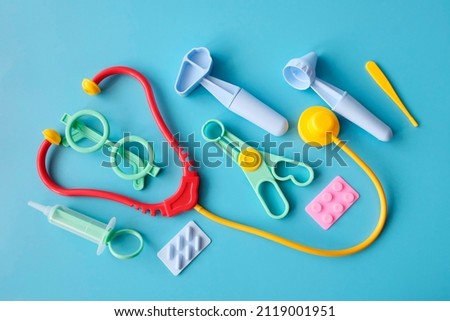 First aid kit for children, toy medical instruments. Game set for development concept. Blue background.