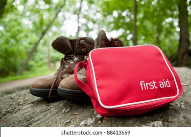 First aid kit and hiking boots in the woods