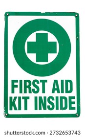 FIRST AID KIT INSIDE. An old metal sign that reads FIRST AID KIT INSIDE. First Aid kits are important in case of an emergency. First aid kit. Information sign with green cross text. Green Cross.
