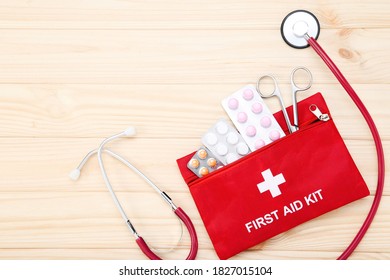 First Aid Kit With Medical Supplies On Brown Wooden Table