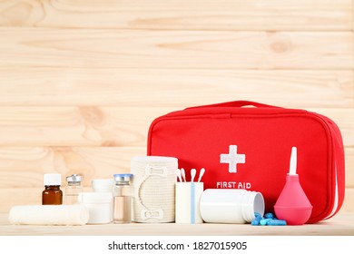 First Aid Kit With Medical Supplies On Brown Wooden Table