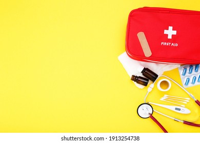 First Aid Kit With Medical Supplies On Yellow Background