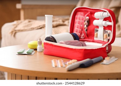 First aid kit with medicines on table in living room