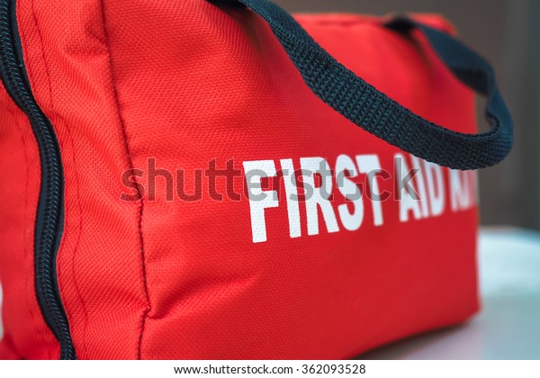 First Aid Kit\
A red first aid kit bag with a\
black zip and handle, in\
closeup.