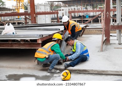 First Aid and safety first concept. Professional engineering teamwork concept. Engineering supervisor helping his coworker lying unconscious at industrial factory. Professional engineering teamwork 