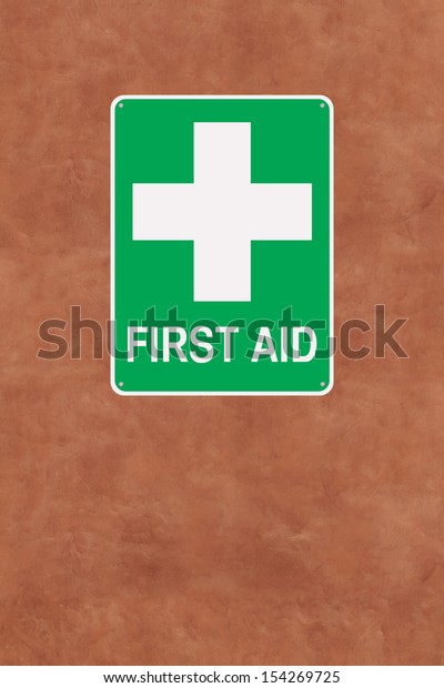 A first aid sign\
mounted on a wall 