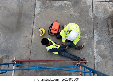First aid support accident at work of construction worker at site. Builder accident falls scaffolding on floor, Safety team helps employee accident. - Shutterstock ID 1628893309