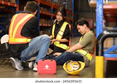 First aid support accident at work of worker at factory. Male worker has an accident on the floor in warehouse site