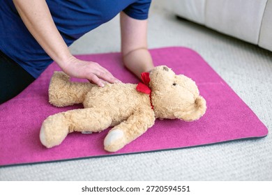 first aid training, CPR practice, cardiopulmonary resuscitation, emergency response, life saving technique, infant simulation, child safety education, teddy bear model, plush toy, soft fabric texture, beige fur surface, red bow accent, training substitute, learning scenario, kneeling posture, adult hands, arm support, torso pressure, chest compression position, instructional demonstration, home environment, indoor setting, carpeted floor, pink exercise mat, foam padding, safety practice space, caregiver role, parenting skills, childcare preparation, emergency preparedness, basic life support, nonverbal instruction, physical guidance, close-up framing, partial body view, cropped subject, casual clothing, blue shirt fabric, neutral lighting, realistic training moment, educational concept, safety awareness, family protection theme, domestic interior, calm atmosphere, controlled movement, instructional photography, health education imagery, prevention training, rescue technique simulation
parental care concept, emotional preparation, baby expectation theme, future parent mindset, nurturing behavior, gentle touch, protective gesture, caregiving instinct, maternal readiness, paternal readiness, family planning idea, newborn anticipation, infant well-being focus, responsibility awareness, early bonding symbolism, tenderness expression, calm reassurance, emotional connection, caregiving practice, learning confidence, preparedness feeling, soft interaction, supportive posture, safety concern, health protection mindset, preventive education, responsible parenting values, home comfort, domestic calm, warmth atmosphere, trust building, caregiving routine concept, baby arrival preparation, child-focused thinking, nurturing environment, emotional security theme, compassion display, loving attention, early parenthood vision, care-oriented lifestyle, family growth symbolism