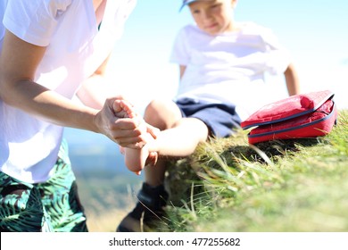 First aid, twisted leg. The child twisted his ankle during a mountain tour. Wound broken leg.