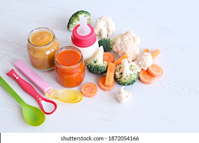 The First Baby Food For Infants From Six Months. Healthy Food And Diet. Vegetables, Jars Of Puree. Carrots, Cauliflower, Broccoli. Infant Formula In A Bottle Or Breast Milk.