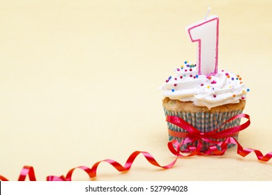 First Birthday Celebration Cupcake With Number One Candle Isolated On Pink Background