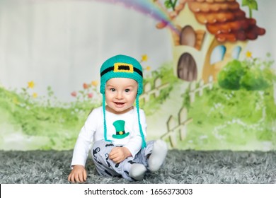 First Birthday Cute Baby Boy Wearing A St. Patrick's Day Hat. Cartoon Fairy House On Background