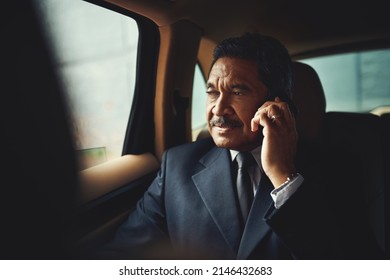 The First Business Call Of The Day. Shot Of A Mature Businessman Using His Phone While Traveling In A Car.