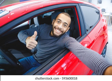 First Car Pic. Handsome Young African Man Smiling Making A Selfie Sitting In His New Car At The Dealership Copyspace Owner Ownership Driver. Buyer Consumerism Lifestyle Travel Concept