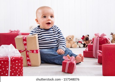 First Christmas: Baby Amongst Red Presents And Is Smiling