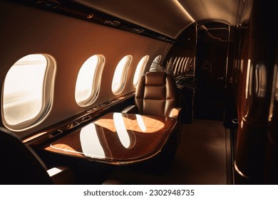 A first class area in a business jet with the sunset through a window - Powered by Shutterstock