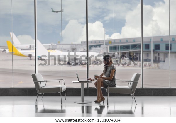 First class business passenger sitting\
in luxury VIP exclusive lounge at airport, on\
laptop